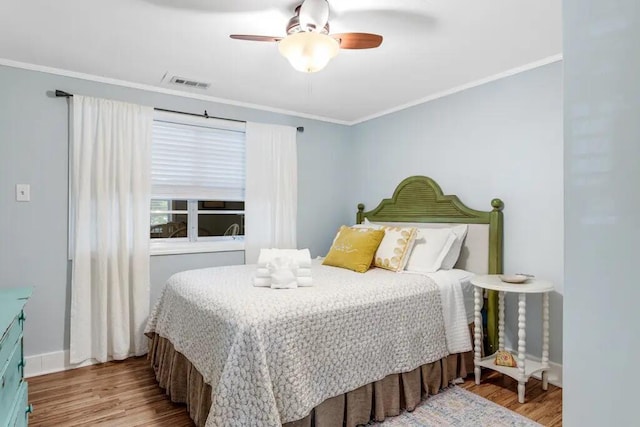 bedroom with light hardwood / wood-style flooring, ceiling fan, and crown molding