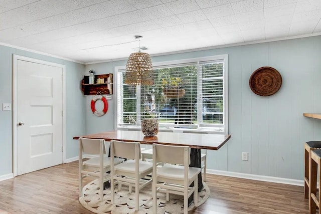 dining room featuring crown molding, a notable chandelier, and hardwood / wood-style flooring