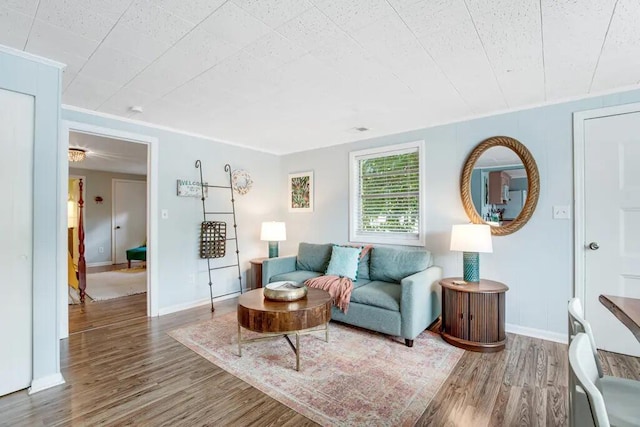 living room with hardwood / wood-style flooring and ornamental molding