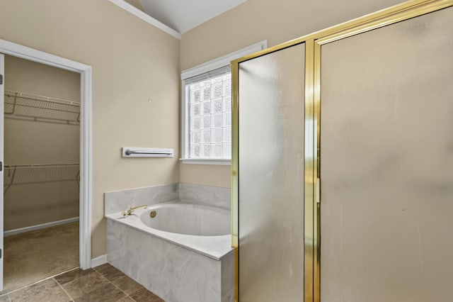 full bath with a garden tub, baseboards, a walk in closet, and a shower stall