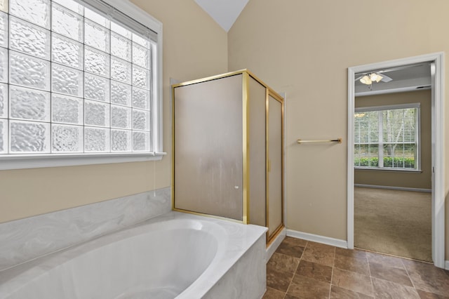 full bathroom featuring vaulted ceiling, a stall shower, a bath, and baseboards