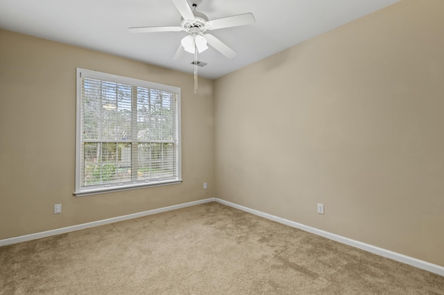 spare room featuring ceiling fan, baseboards, and light colored carpet