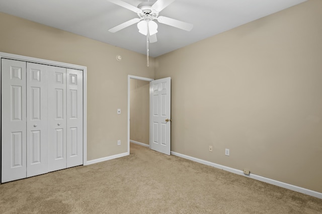 unfurnished bedroom with ceiling fan, baseboards, a closet, and light colored carpet