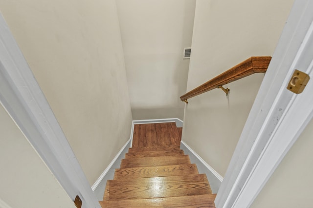 stairway with baseboards and visible vents