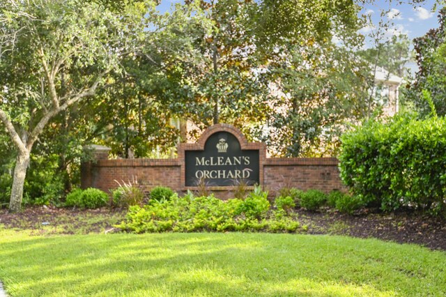 community / neighborhood sign with a yard