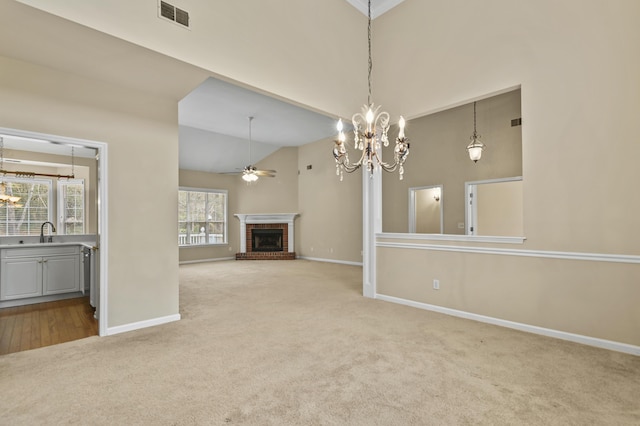 unfurnished living room featuring light carpet, a brick fireplace, visible vents, and a sink