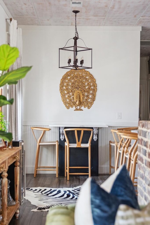 dining room featuring a chandelier, wood finished floors, and wainscoting