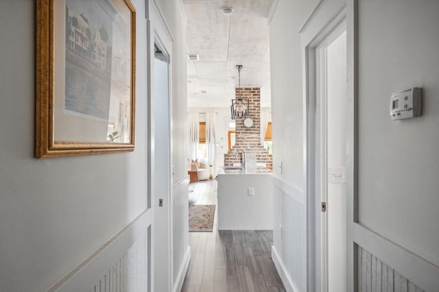 corridor featuring wood finished floors and a sink