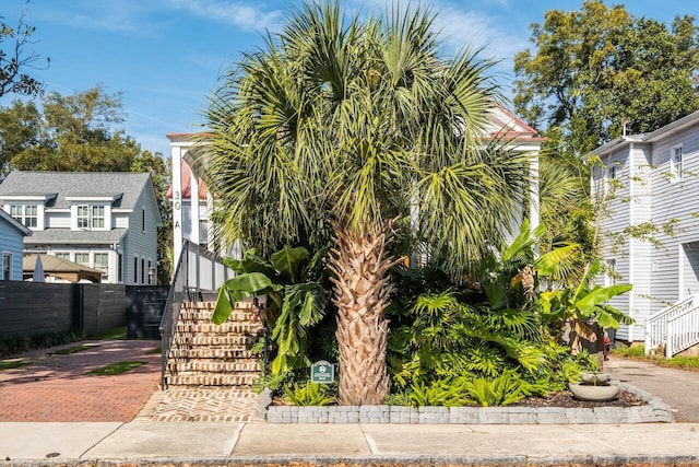 view of property exterior with stairway and fence