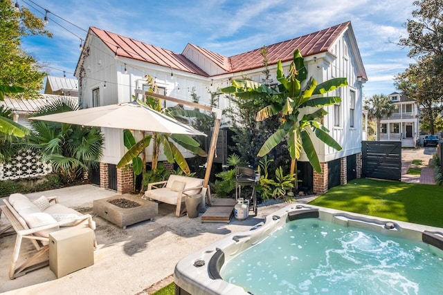 view of swimming pool with a fire pit, a hot tub, and a patio
