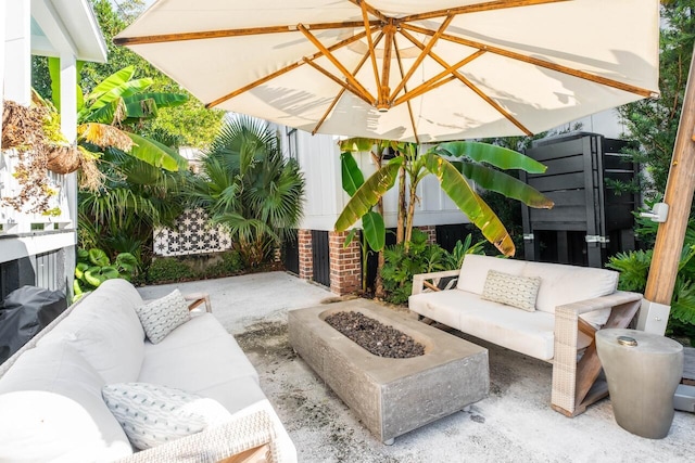 view of patio with an outdoor living space with a fire pit