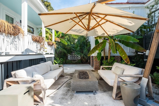 view of patio with an outdoor living space with a fire pit