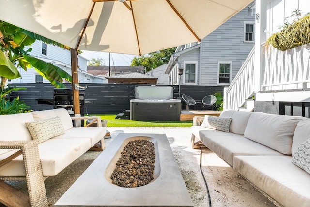 view of patio featuring an outdoor living space with a fire pit, a hot tub, and fence