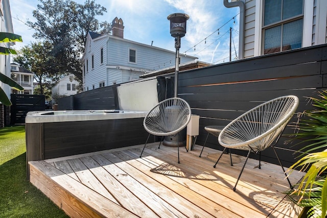 wooden deck featuring a hot tub and fence