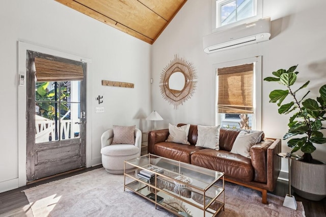 living area featuring a wall unit AC, healthy amount of natural light, vaulted ceiling, and wood finished floors