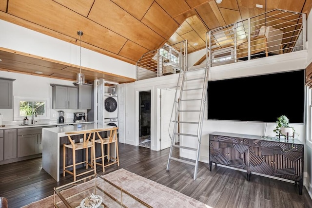 living room with wooden ceiling, estacked washer and dryer, dark wood-type flooring, and lofted ceiling