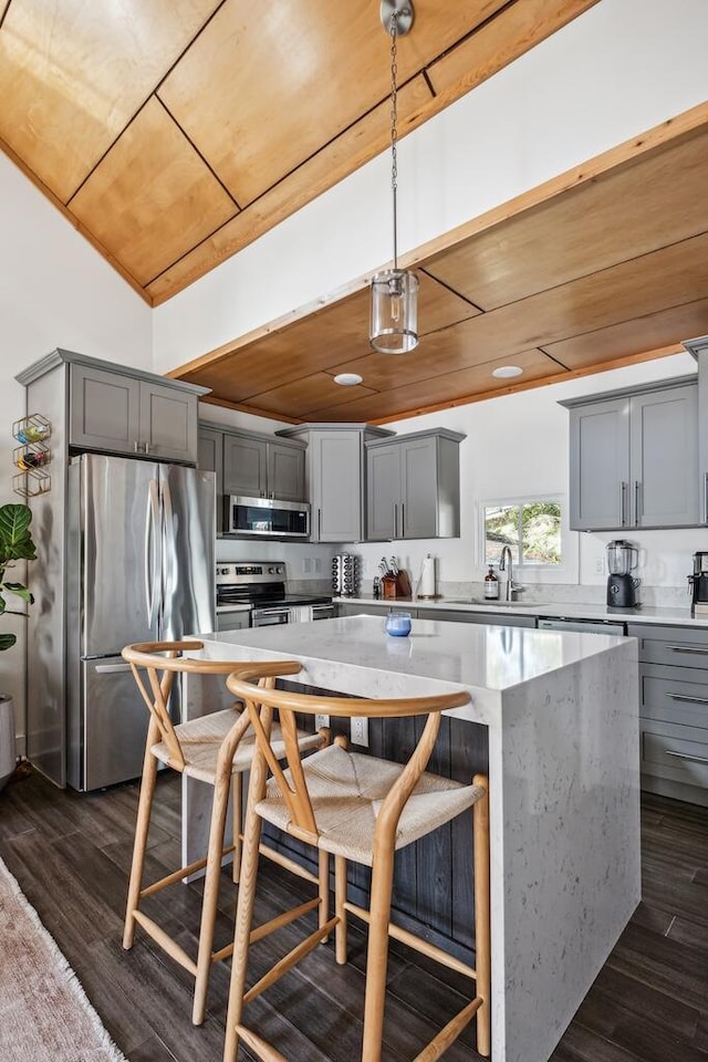 kitchen featuring stainless steel appliances, wooden ceiling, gray cabinetry, a kitchen island, and pendant lighting