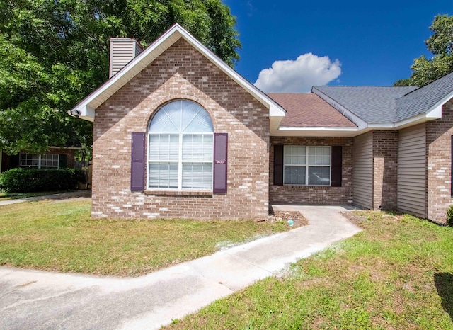9630 N Cardinal Dr, Ladson, SC 29456 - ranch-style house featuring brick siding, a chimney, a front yard, and a shingled roof