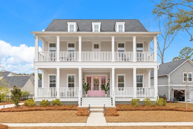 view of front of house featuring french doors, a balcony, and covered porch