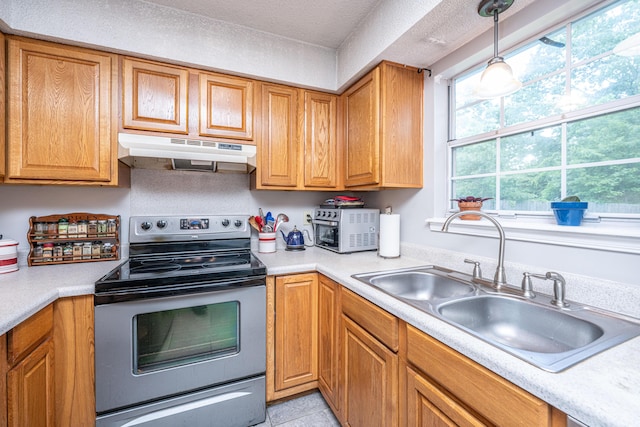 kitchen with a sink, light countertops, under cabinet range hood, and electric range