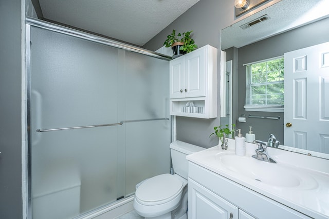 bathroom with visible vents, vanity, toilet, a textured ceiling, and a stall shower