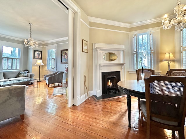 dining space featuring hardwood / wood-style floors, crown molding, and a chandelier