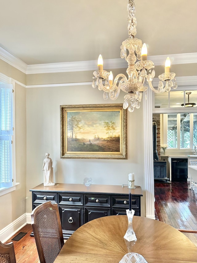 dining room featuring dark hardwood / wood-style flooring, crown molding, and an inviting chandelier