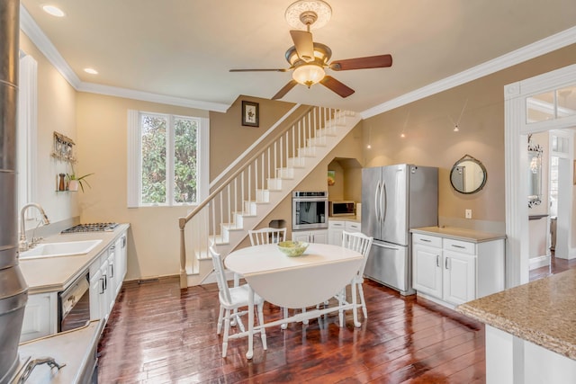 dining room with dark wood-type flooring, crown molding, and sink