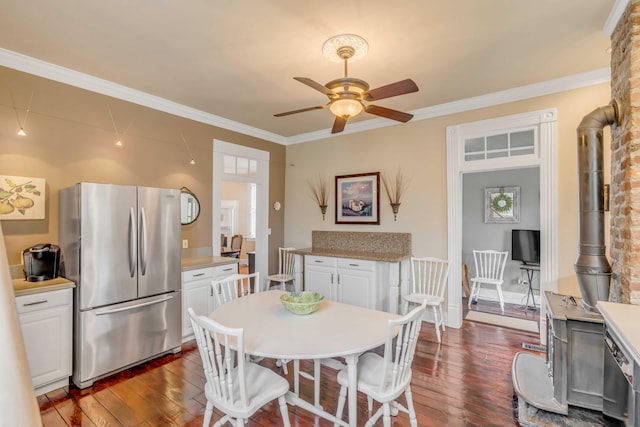 dining room featuring a wood stove, dark wood-type flooring, and crown molding