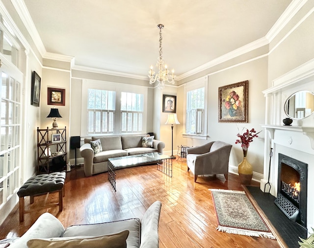 living room featuring wood-type flooring, ornamental molding, and a notable chandelier