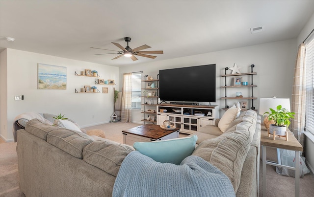 living room featuring ceiling fan, light carpet, and a healthy amount of sunlight