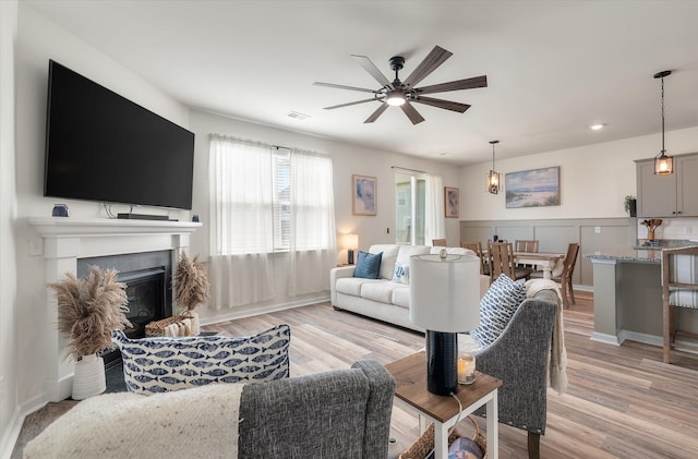 living room featuring light hardwood / wood-style flooring and ceiling fan