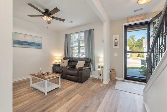 living room with light hardwood / wood-style floors and ceiling fan