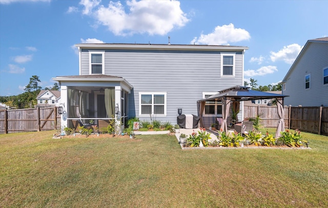 rear view of property featuring a yard, a patio area, a sunroom, and a gazebo