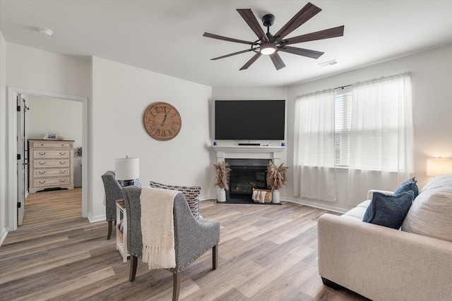 living room with wood-type flooring and ceiling fan