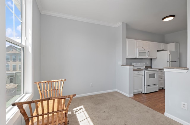 kitchen with dark colored carpet, crown molding, white cabinets, and white appliances