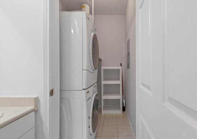 laundry area with light tile patterned floors and stacked washer / dryer