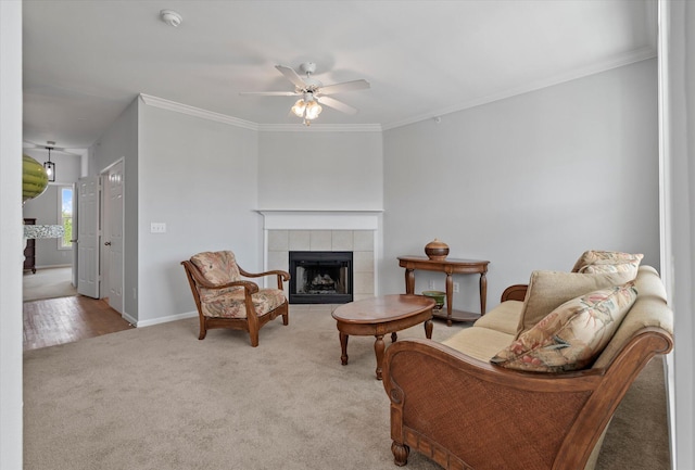 sitting room with ceiling fan, crown molding, light colored carpet, and a tile fireplace