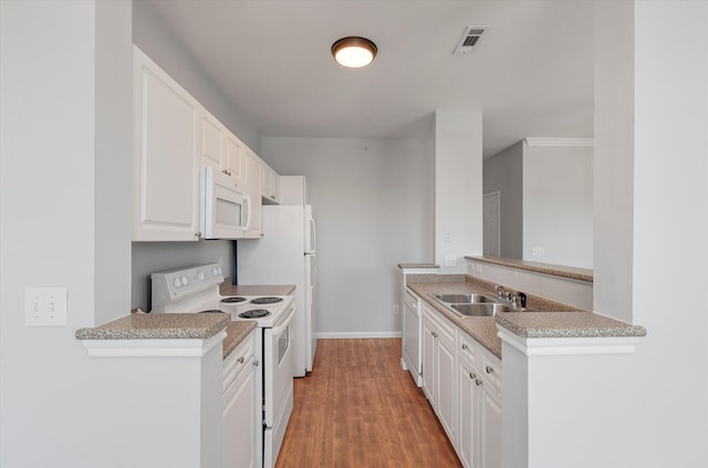 kitchen with white cabinetry, light hardwood / wood-style floors, kitchen peninsula, white appliances, and sink