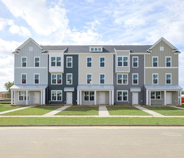 138 Yorkshire Dr, Moncks Corner, SC 29461 - townhome / multi-family property with board and batten siding, a front yard, a standing seam roof, and metal roof