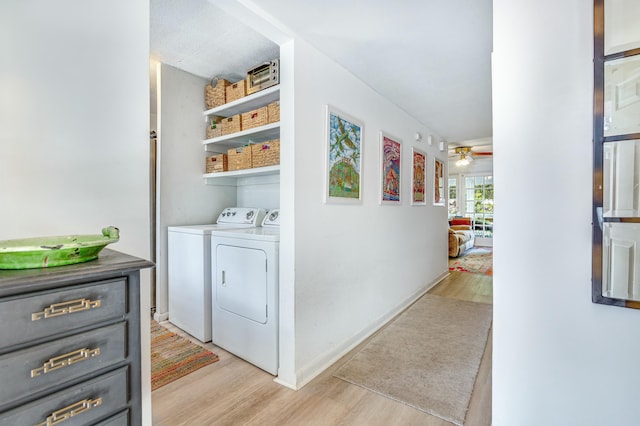 laundry room featuring washing machine and dryer, ceiling fan, and light hardwood / wood-style flooring