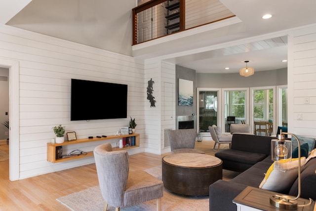 living room with wooden walls and light hardwood / wood-style floors