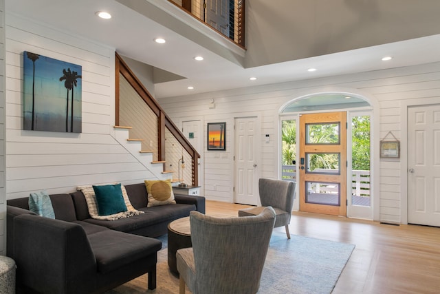 living room with light wood-type flooring and wooden walls