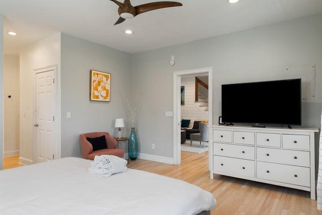 bedroom featuring ensuite bathroom, light hardwood / wood-style flooring, and ceiling fan