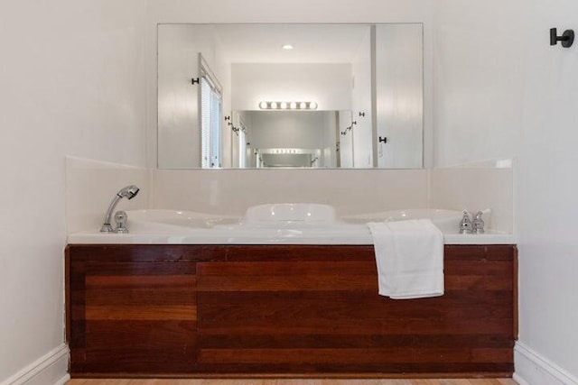 bathroom featuring vanity and a tub