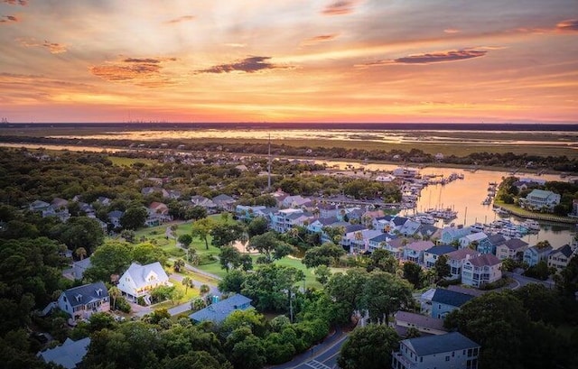 aerial view at dusk featuring a water view