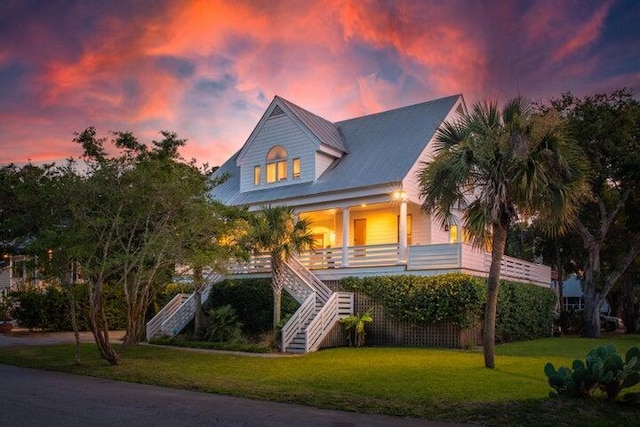 view of front of property with a porch and a yard