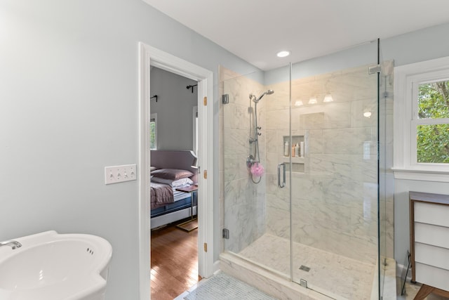 bathroom with hardwood / wood-style flooring, sink, and walk in shower