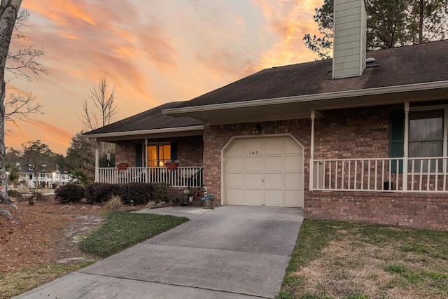 view of front of property with an attached garage, a porch, concrete driveway, and brick siding