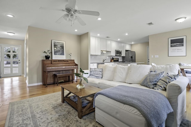 living room featuring ceiling fan and light wood-type flooring